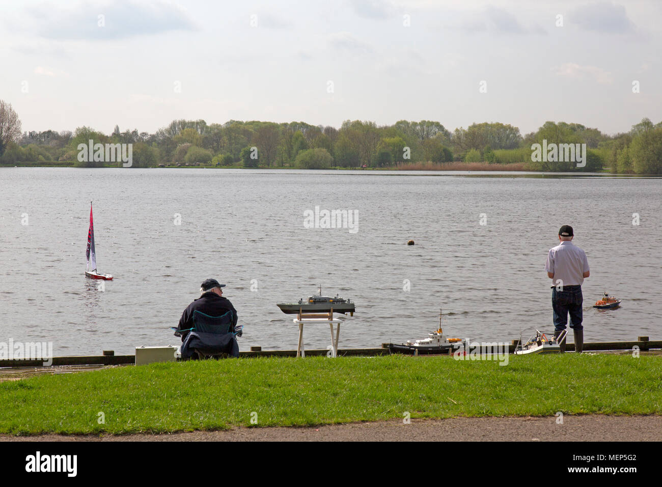 Watermead Country Park nel Leicestershire, in Inghilterra. Due uomini maturi giocando con le loro barche di modello su uno dei numerosi laghi nel parco. Foto Stock