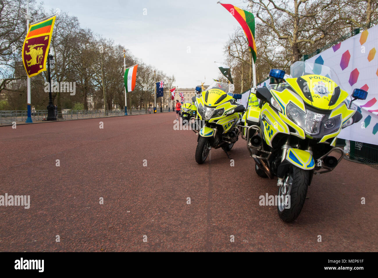 Moto della polizia sul Mall per i capi di governo del Commonwealth vertice di aprile 2018 mentre i ciclisti ciclo da sotto il più flag Foto Stock