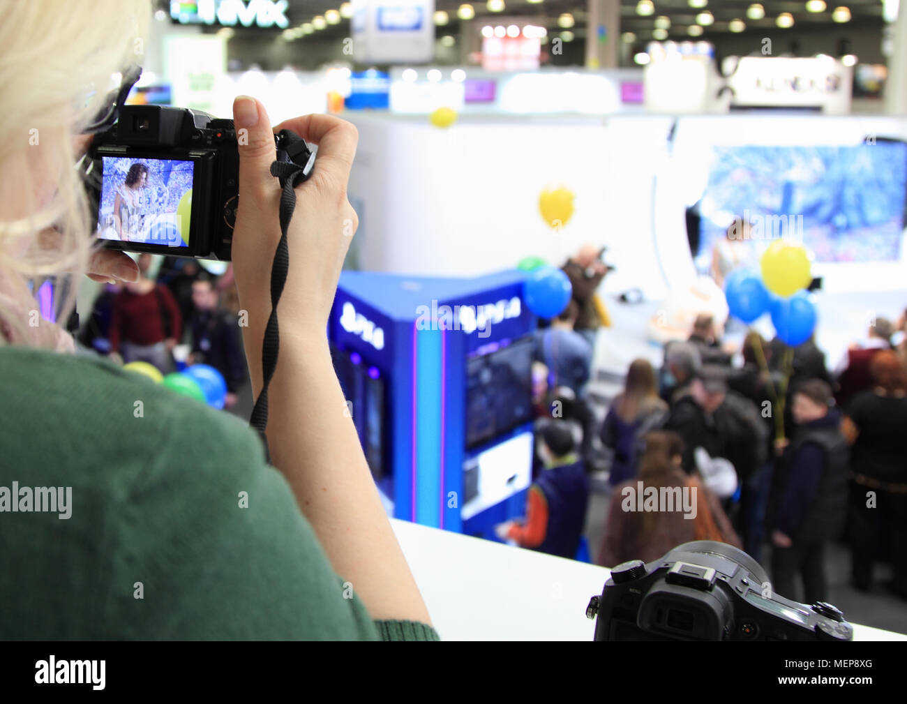 Russia, Mosca, 12 aprile 2014. Forum per i fotografi. Donna fotografo scatta l'evento. Foto Stock