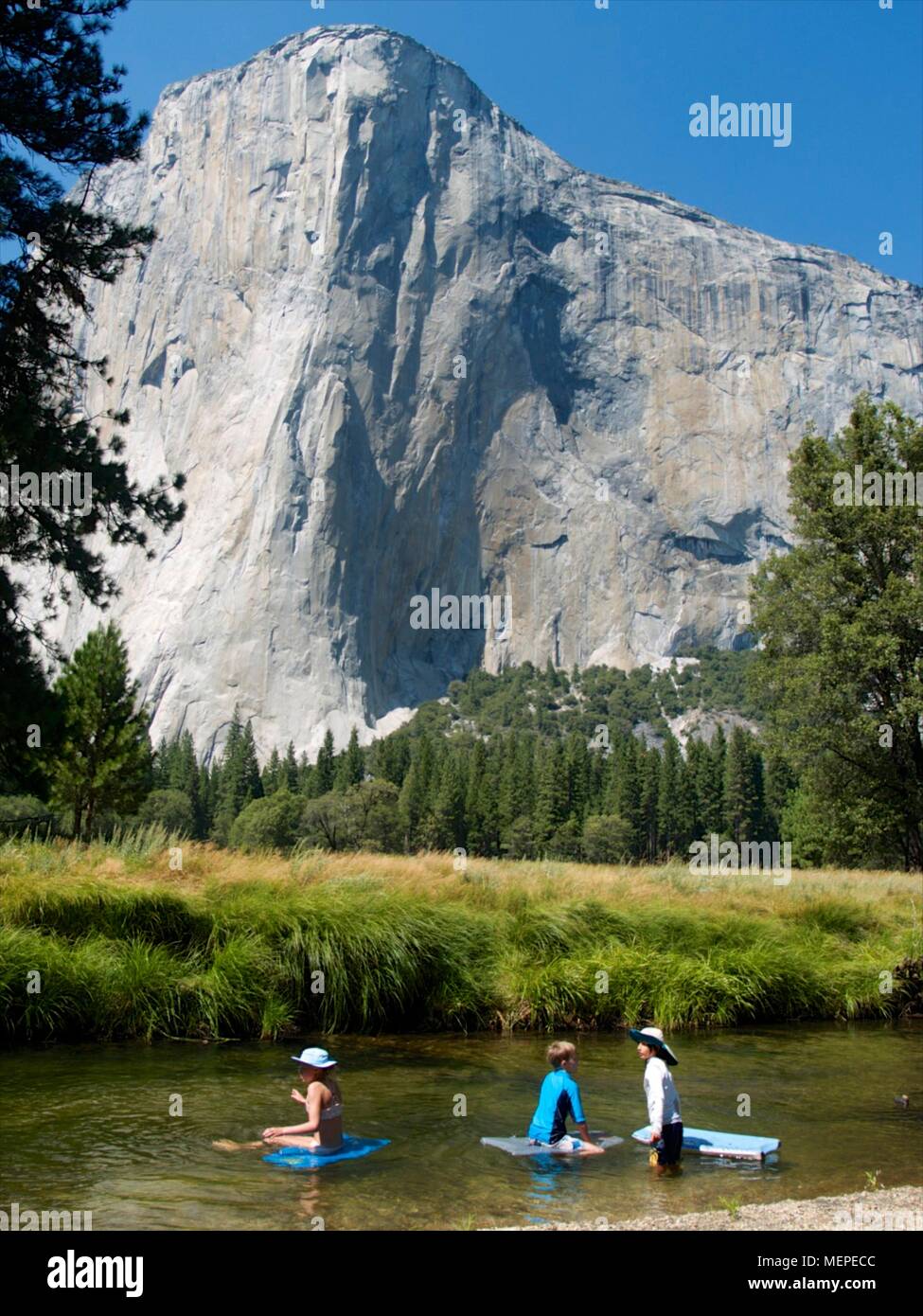 Bambini che giocano nel fiume Merced al di sotto di El Capitan in Yosemite Valley Foto Stock