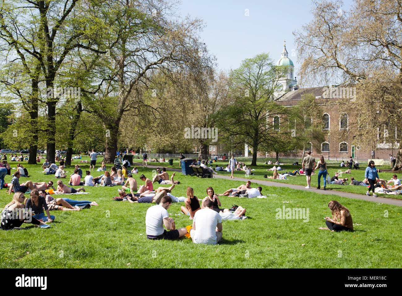 La gente sul prato in Clapham Common in una calda giornata di primavera - London REGNO UNITO Foto Stock