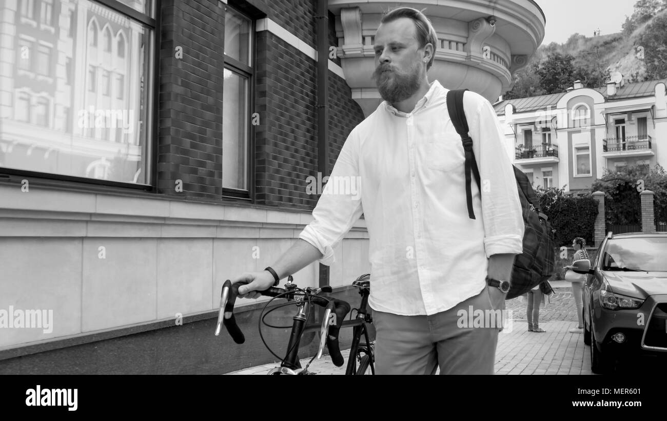Bianco e nero ritratto di Giovane hipster uomo a camminare sulla strada Foto Stock