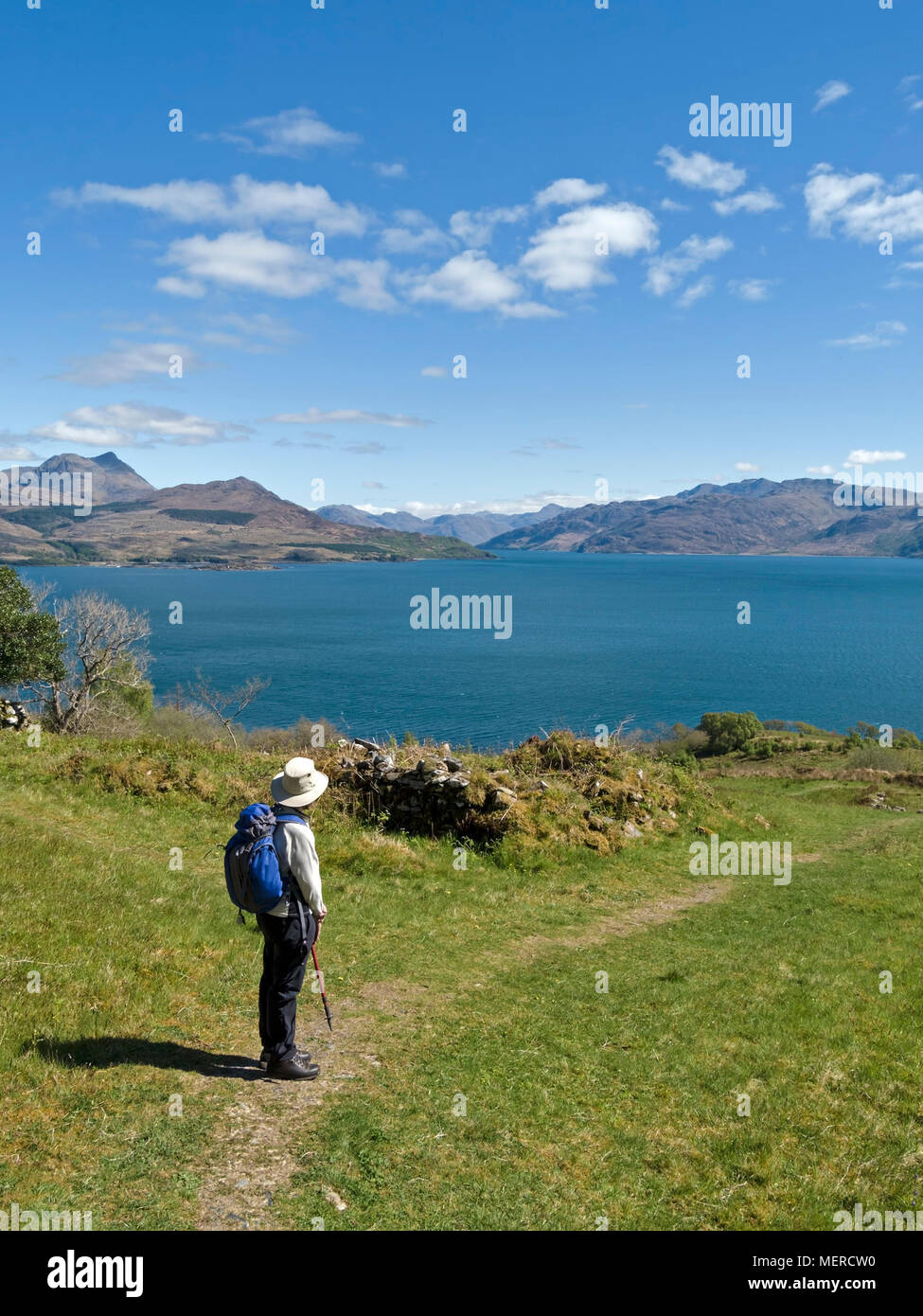 Visitatore a Leitir Fura sull'Isola di Skye, osservando la vista attraverso Sound of Skye fino alle montagne delle Highlands scozzesi, costa occidentale della Scozia, Regno Unito Foto Stock