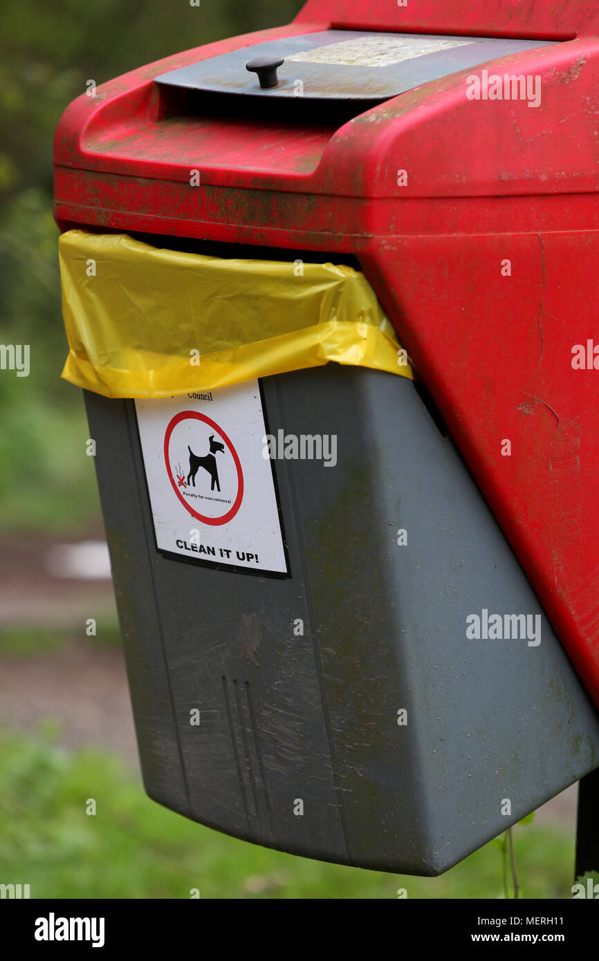 Un rosso brillante e Grey Dog Poo bin in Southwater Country Park, Horsham, Regno Unito. Foto Stock
