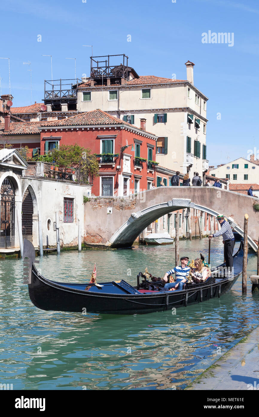 Impostazione del gondoliere off con i turisti in una gondola per un gita turistica sotto il Ponte Cavallo, Cannaregio, Venezia, Italia Foto Stock