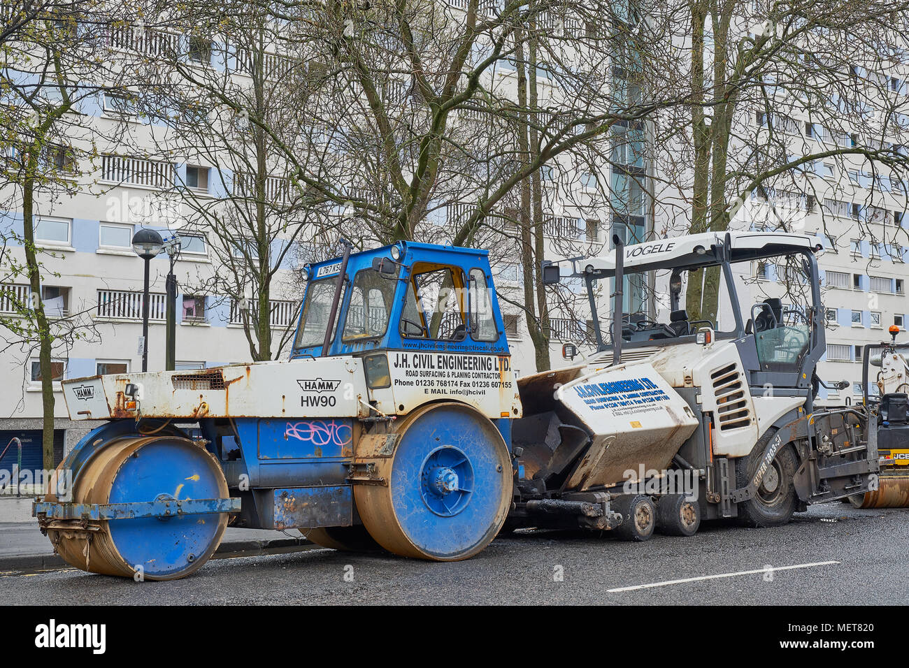 Caricatore di scavo e rullo di vapore manto stradale attrezzature di riparazione Glasgow Scozia Scotland Foto Stock