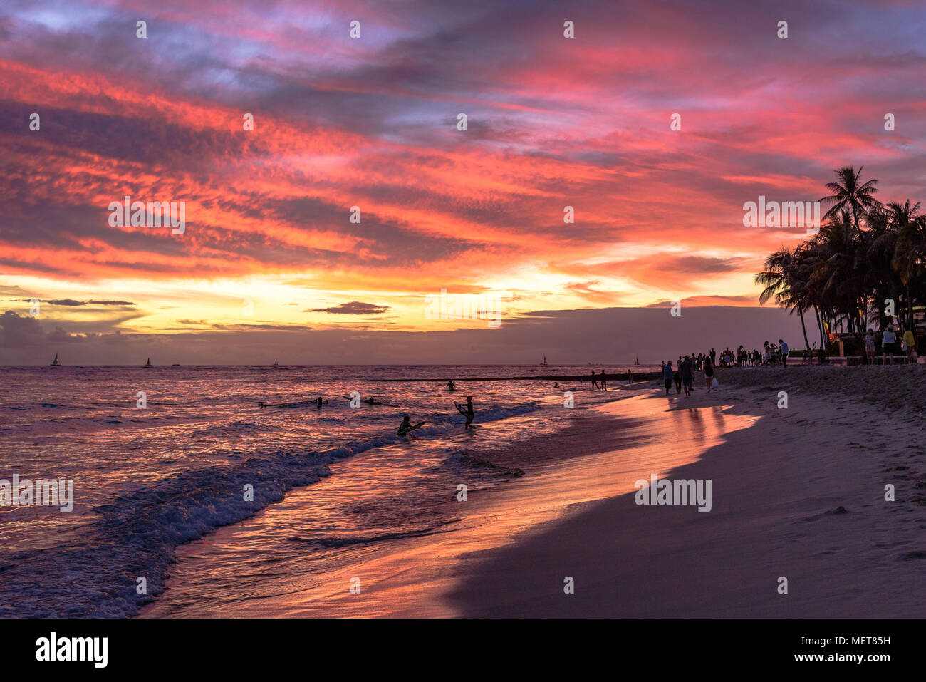 Sagome al tramonto sulla spiaggia di Waikiki Beach, Hawaii Foto Stock