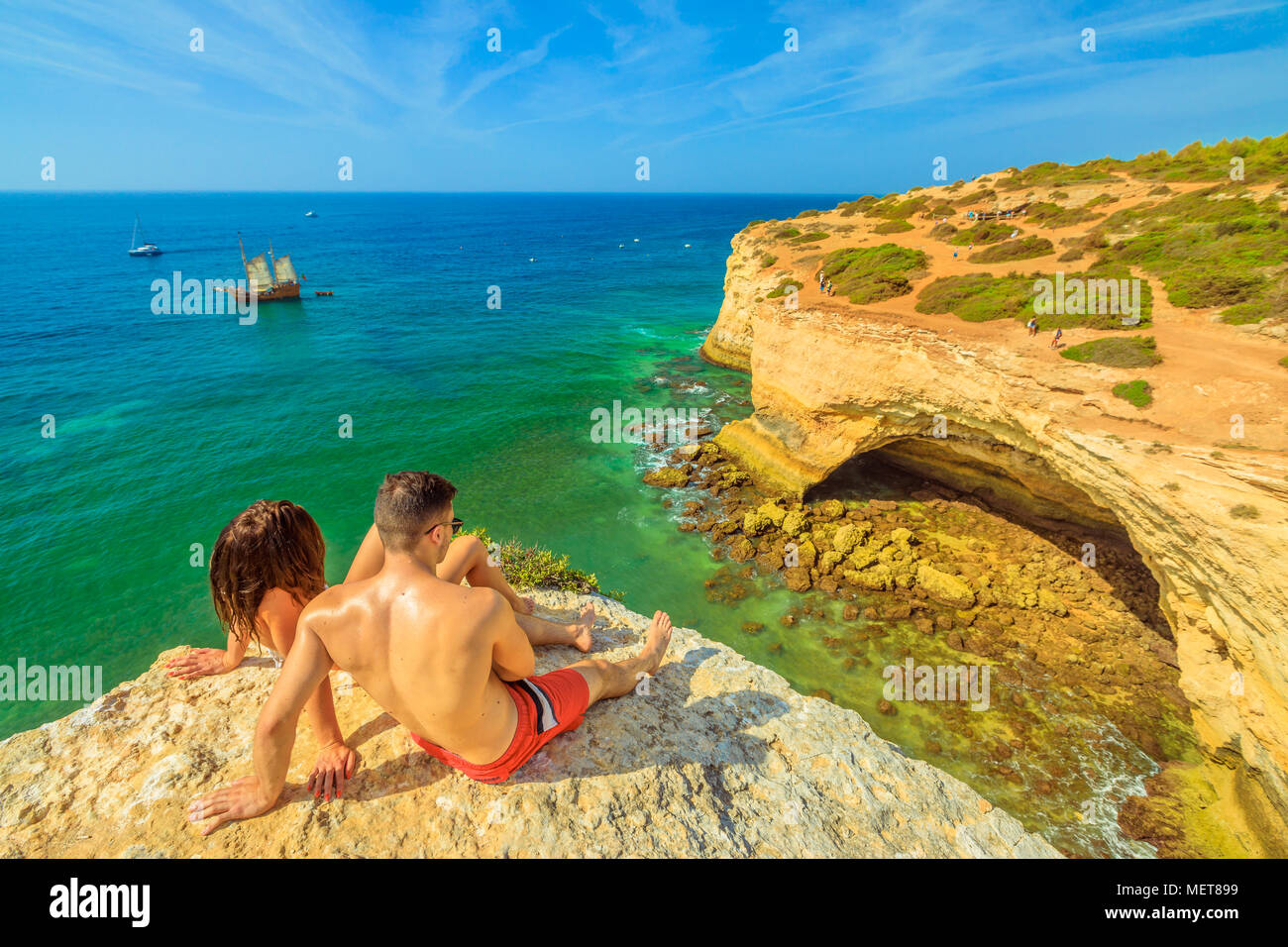 A Benagil, Portogallo - Agosto 23, 2017: lo stile di vita matura in estate vacanze, a prendere il sole sulle scogliere in Costa Algarve famoso per le sue formazioni rocciose. A Benagil grotta, una famosa grotta di mare sulla scogliera di fronte. Foto Stock
