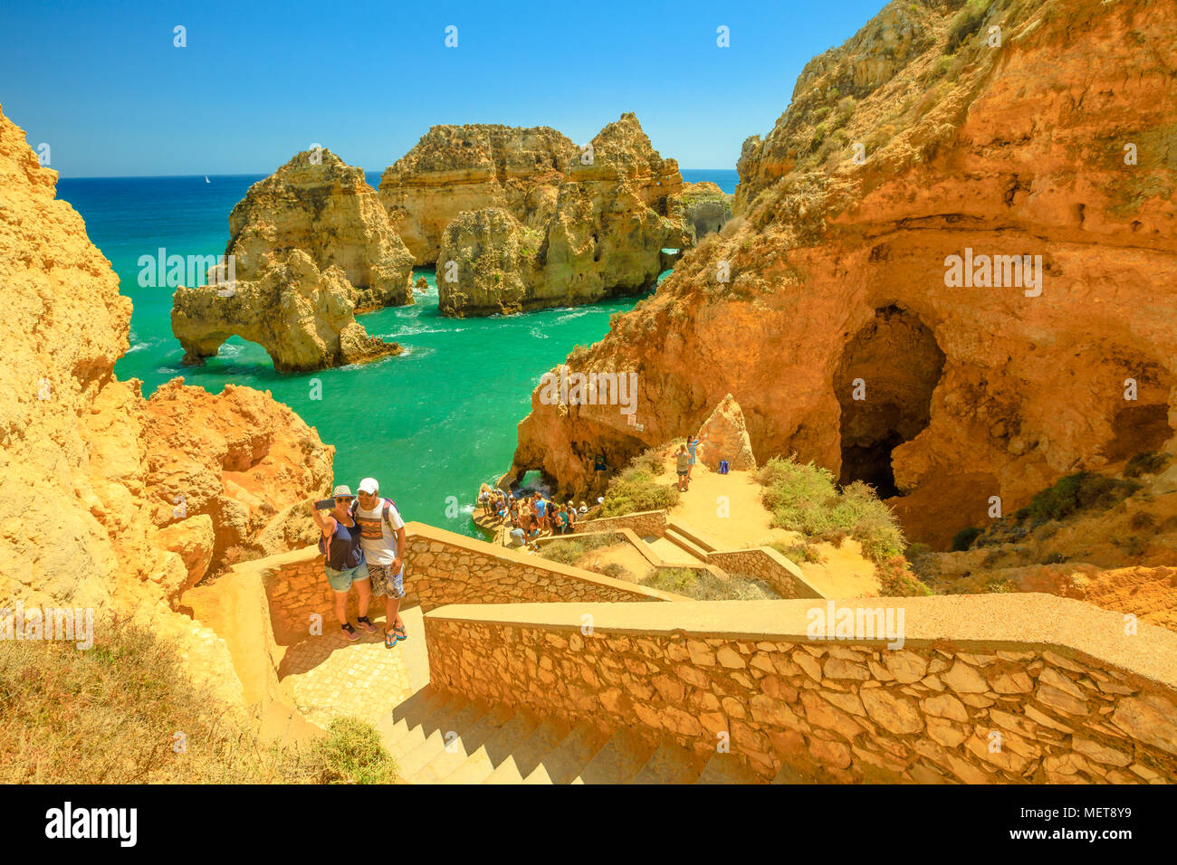 Lagos, Portogallo - Agosto 22, 2017: coppie prendere selfie sui gradini che conducono in basso verso le grotte a Ponta da Piedade a Lagos, una delle principali destinazioni turistiche della Costa Algarve, Portogallo. Giornata di sole. Foto Stock