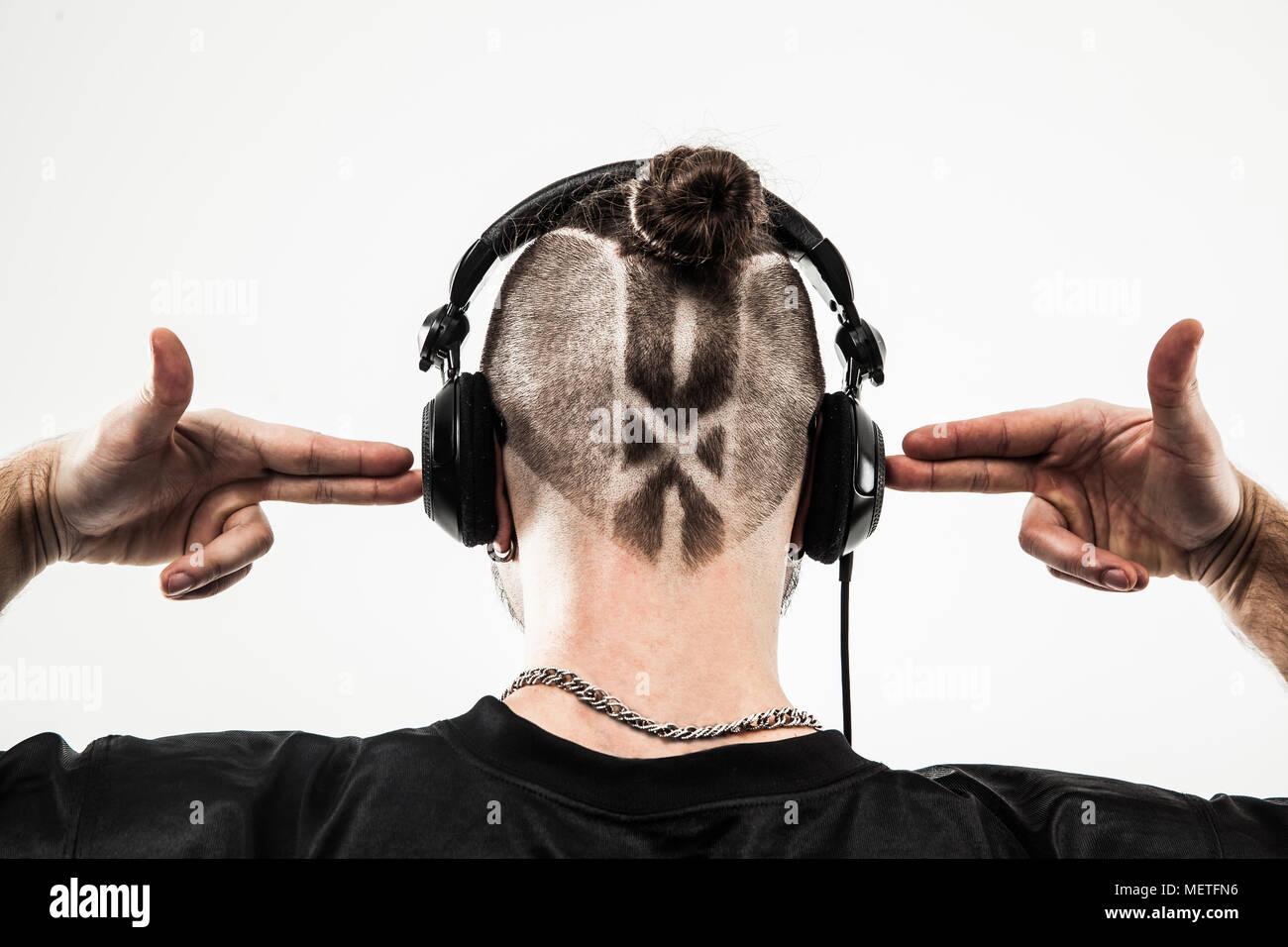 Vista posteriore - il rapper cuffie con un elegante taglio di capelli e un  tatuaggio.foto su sfondo bianco Foto stock - Alamy
