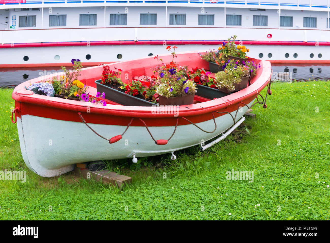 Decorativo modello Vintage in legno antico imbarcazione a remi pieno di fiori. Paesaggio Foto Stock