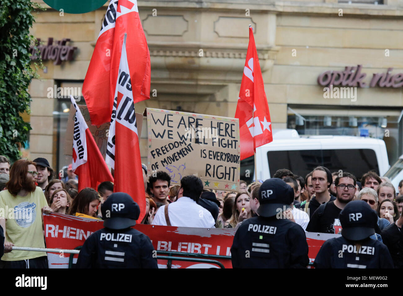 Mainz, Germania. Il 23 aprile 2018. Il contatore-manifestanti protesta con striscioni e bandiere appena al di fuori della vista da destra protestare, separati da funzionari di polizia. Intorno 50 a destra i dimostranti si sono stretti nel centro città di Magonza, per protestare contro il governo tedesco, per la chiusura delle frontiere e contro i rifugiati sotto lo slogan "erkel ha per andare'. Essi sono stati heckled da circa 350 contro i manifestanti. Credito: Michael Debets/Alamy Live News Foto Stock