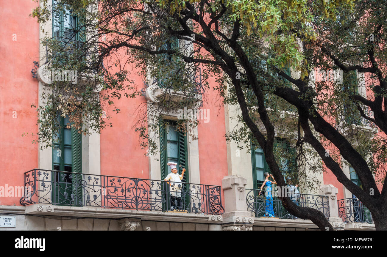 Mannequins stand su balconi nel quartiere gotico di Barcellona guardando fuori in strada sotto. Foto Stock