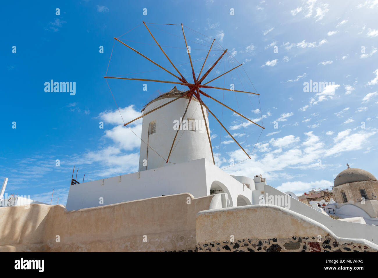 Bassa e un ampio angolo di visione del mulino a vento villa a Oia - Santorini, Grecia con cielo blu come sfondo durante il giorno soleggiato. Foto Stock