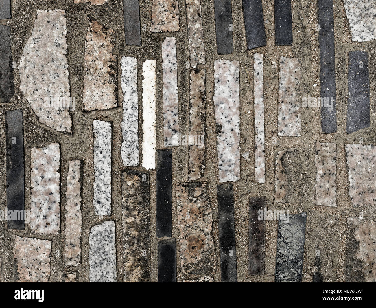Sfondo del marciapiede in calcestruzzo sono decorate con un mix di colore nero, bianco e grigio, macerie o resto o rottami di granito o marmo piastrelle messo in verticale modello astratto Foto Stock