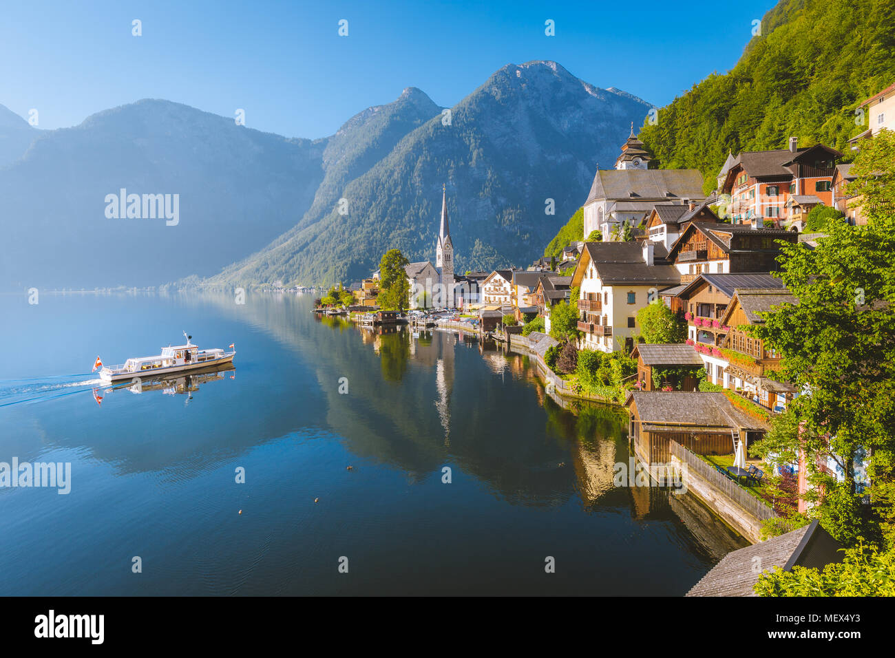 Classic vista da cartolina famosa Hallstatt Lakeside Town con nave tradizionale in bella la luce del mattino al sorgere del sole in estate, Salzkammergut, Austria Foto Stock