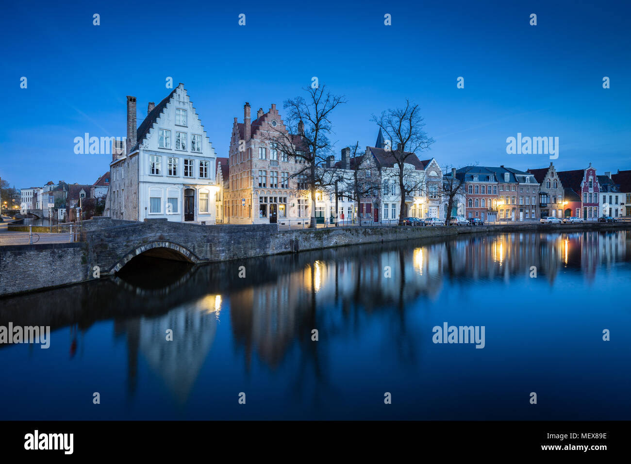 Crepuscolo bella vista del centro storico della città di Brugge con vecchie case lungo il famoso Canal Potterierei accesa durante il blue ora al crepuscolo Foto Stock