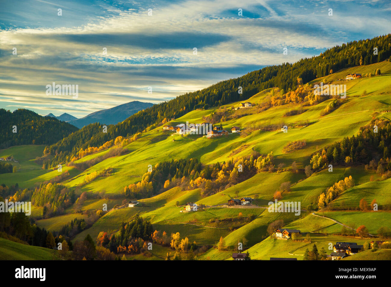 Bellissima vista idilliaco paesaggio di montagna con prati verdi nelle Dolomiti in beautiful Golden luce della sera al tramonto, Val di Funes, Alto Adige Foto Stock