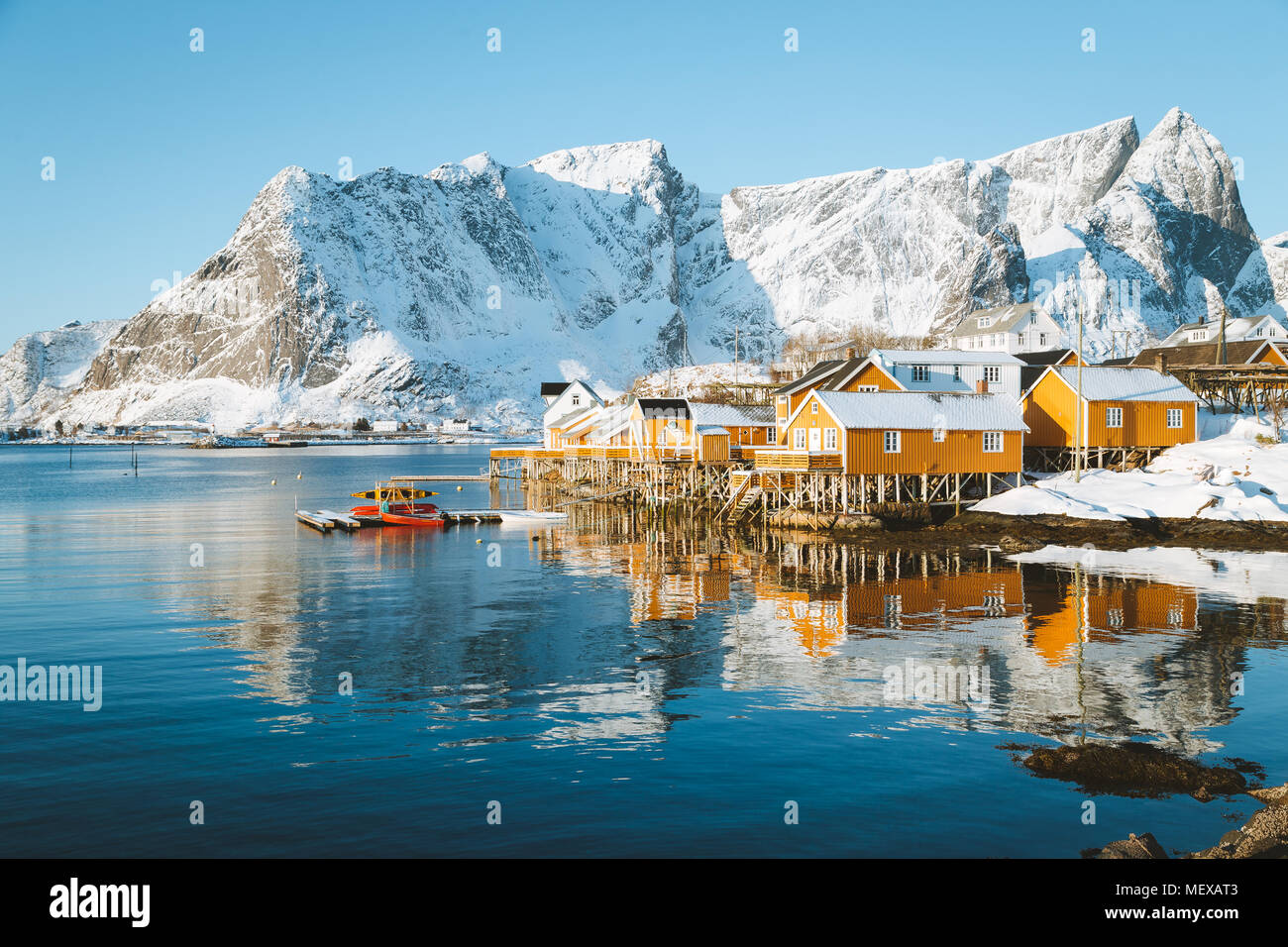 Scenic Isole Lofoten arcipelago paesaggio invernale con il tradizionale giallo pescatore cabine Rorbuer nello storico villaggio di Sakrisoy nei, Norvegia Foto Stock