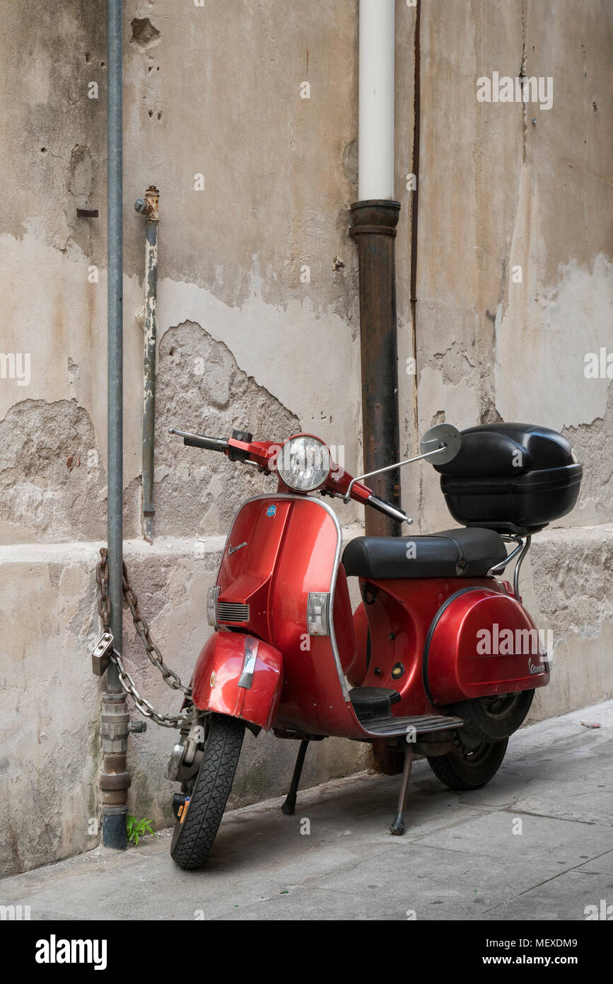 Un vecchio rosso scooter Vespa con top box parcheggiata su una strada a  Palermo, Sicilia, Italia Foto stock - Alamy
