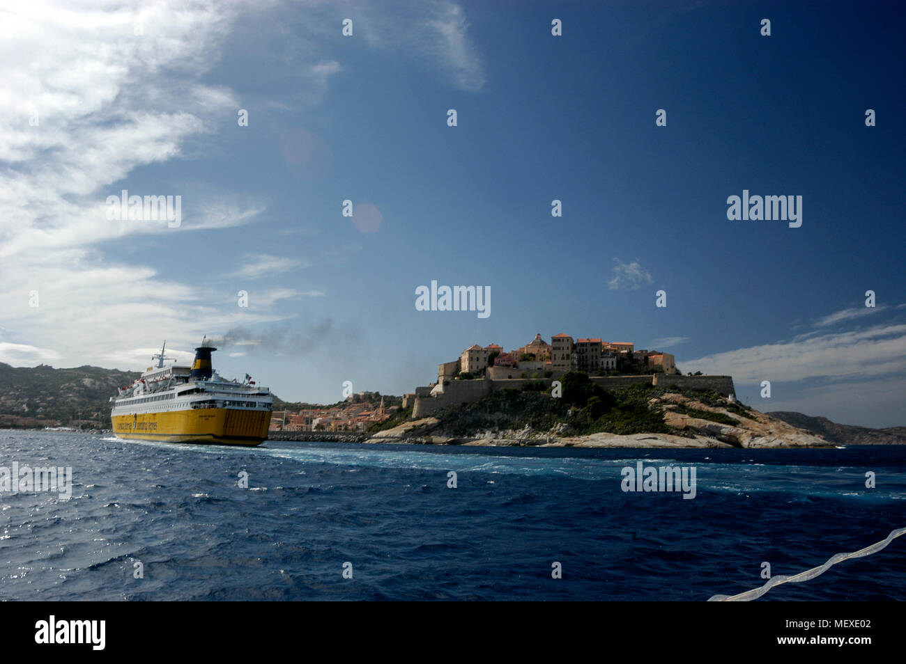 Un passeggero/ traghetto per auto, Corsica ferries e Sardinia Ferries in avvicinamento al porto di Calvi in Corsica come vele passato la cittadella di Calvi su una collina. Th Foto Stock