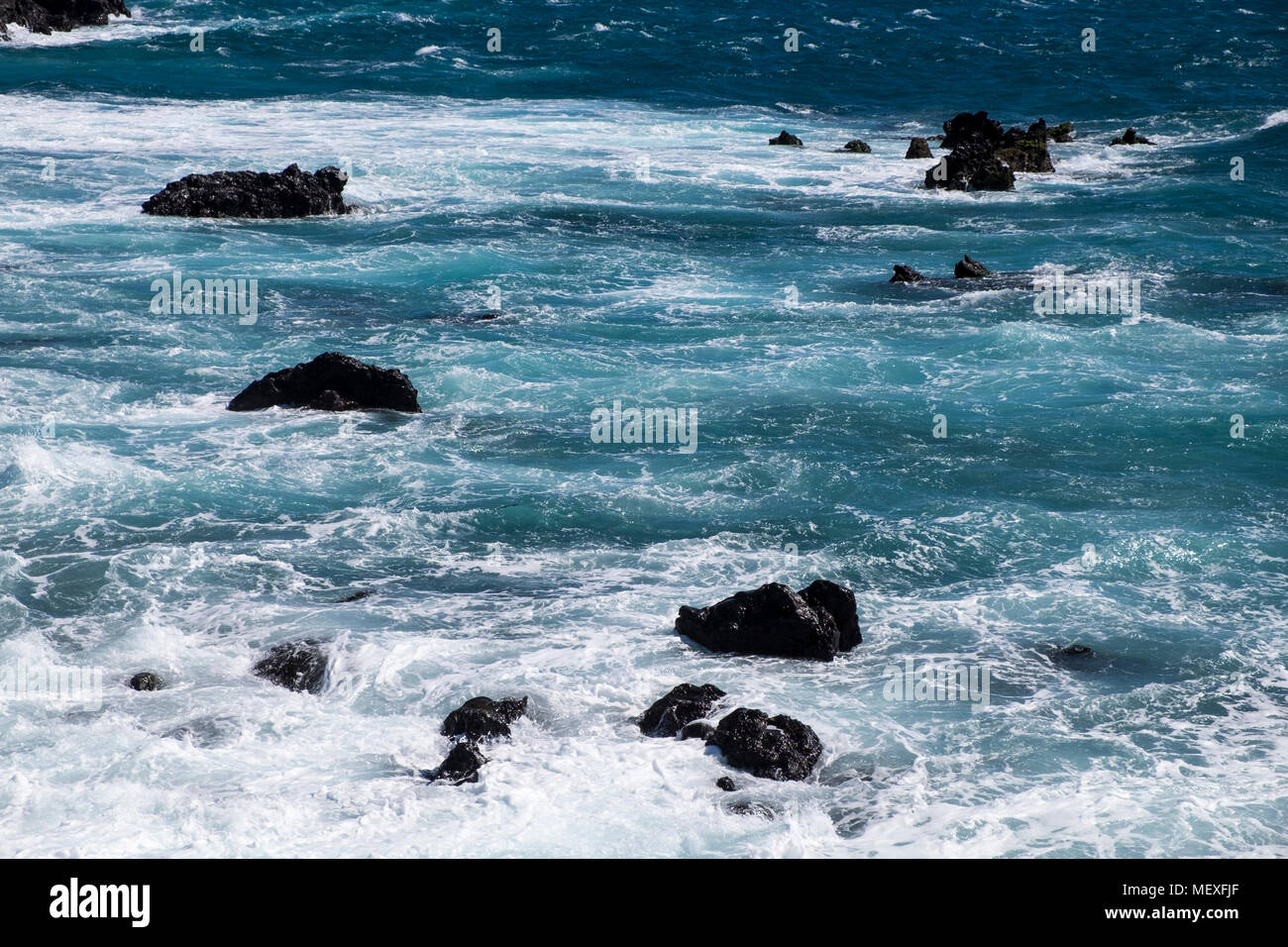 Mare mosso la rottura su rocce lungo la costa occidentale di Tenerife a Playa San Juan, Isole Canarie, Spagna Foto Stock