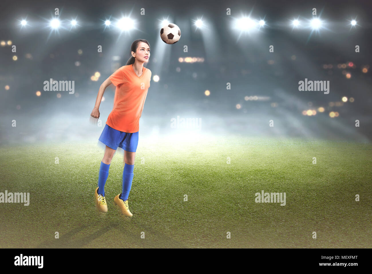 Professional football asiatici ployer donna jump con sfera sulla partita Foto Stock