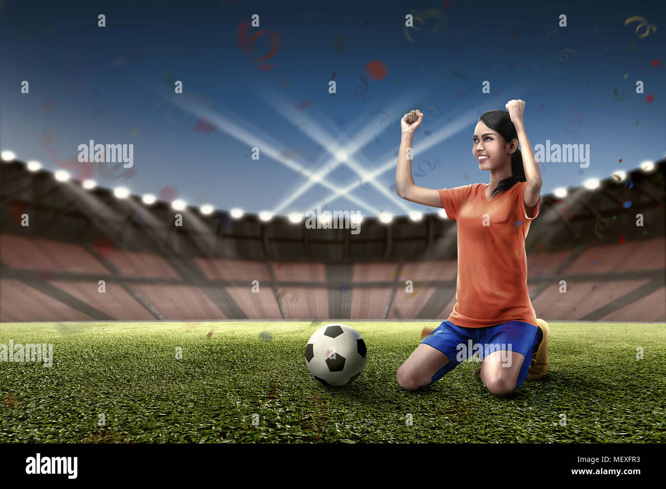 Eccitazione femminile asiatica giocatore di football celebra la sua vittoria sul campo Foto Stock