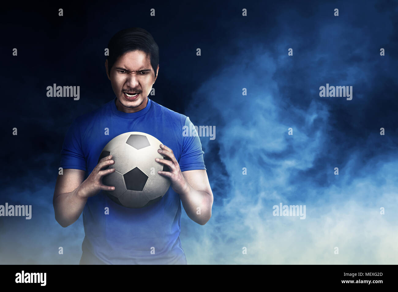 Bello il calcio asiatico giocatore in possesso della palla con sfondo drammatico Foto Stock