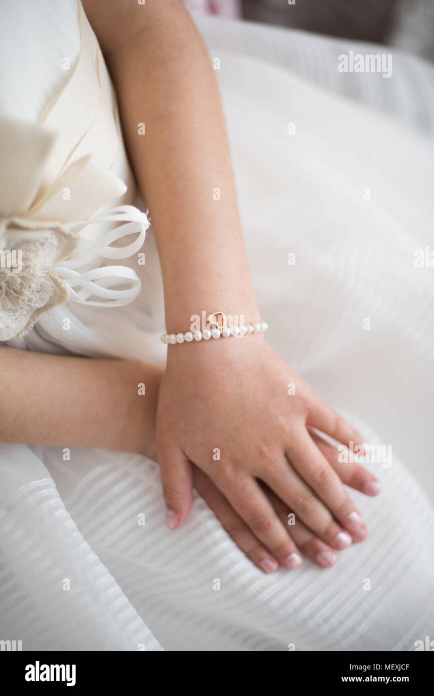 Un bellissimo bracciale sul bambino la mano di una ragazza. Foto Stock