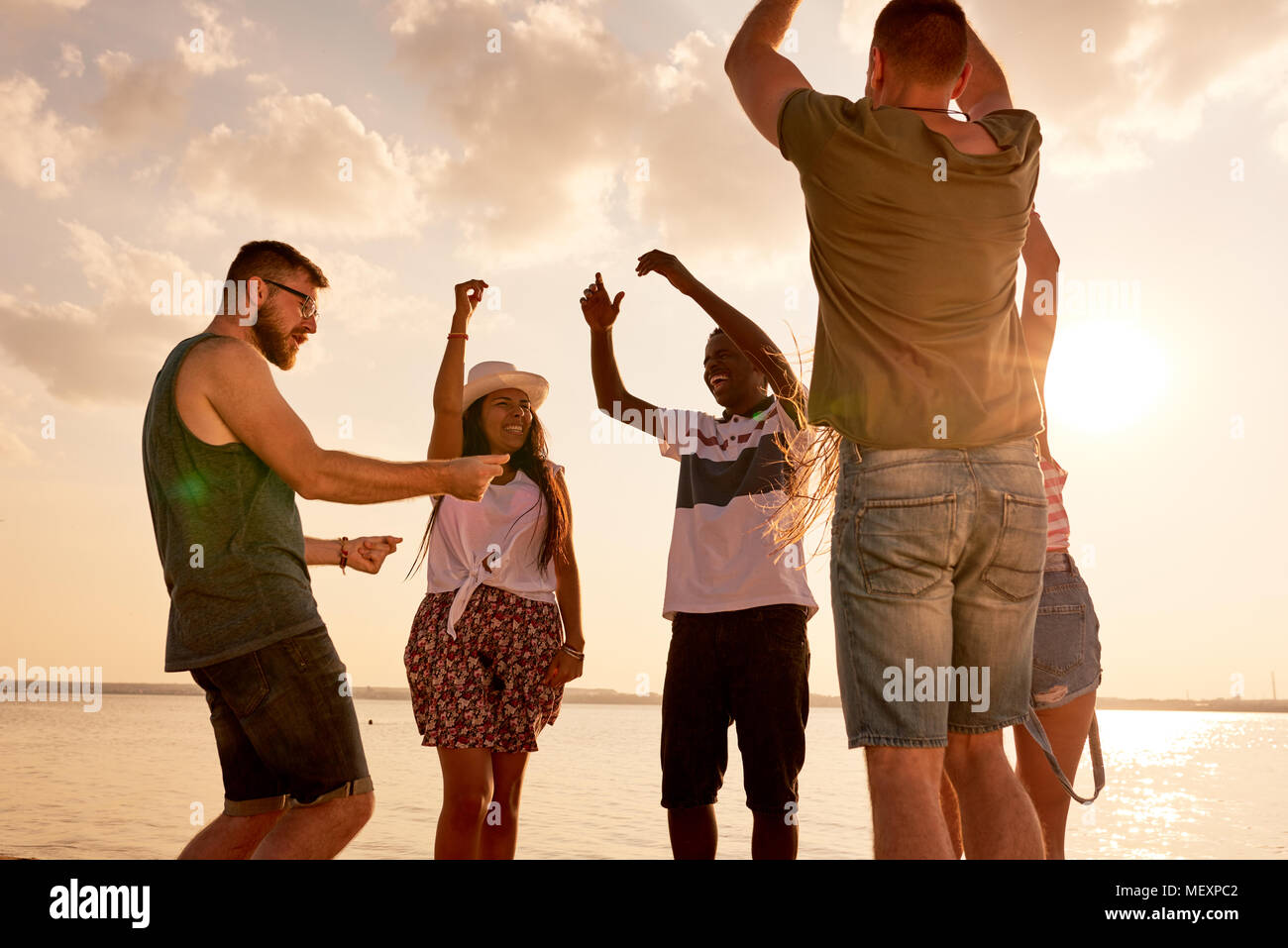 Emozionato amico multietnica ballando sul litorale Foto Stock