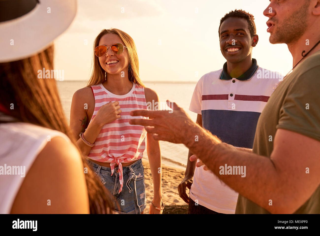 Positivo giovani amici in chat sulla spiaggia Foto Stock