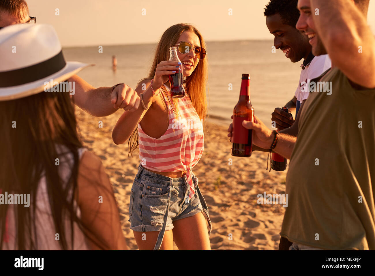 Carefree gli amici a bere birra al beach party Foto Stock