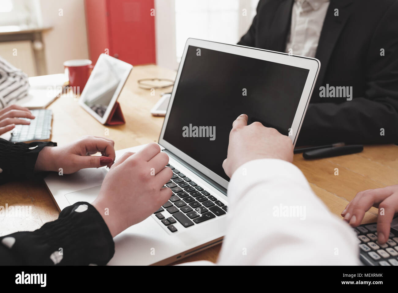 Young business team lavorano insieme come un gruppo sulla scrivania in ufficio con più dispositivi elettronici e carta basata su strumenti Foto Stock
