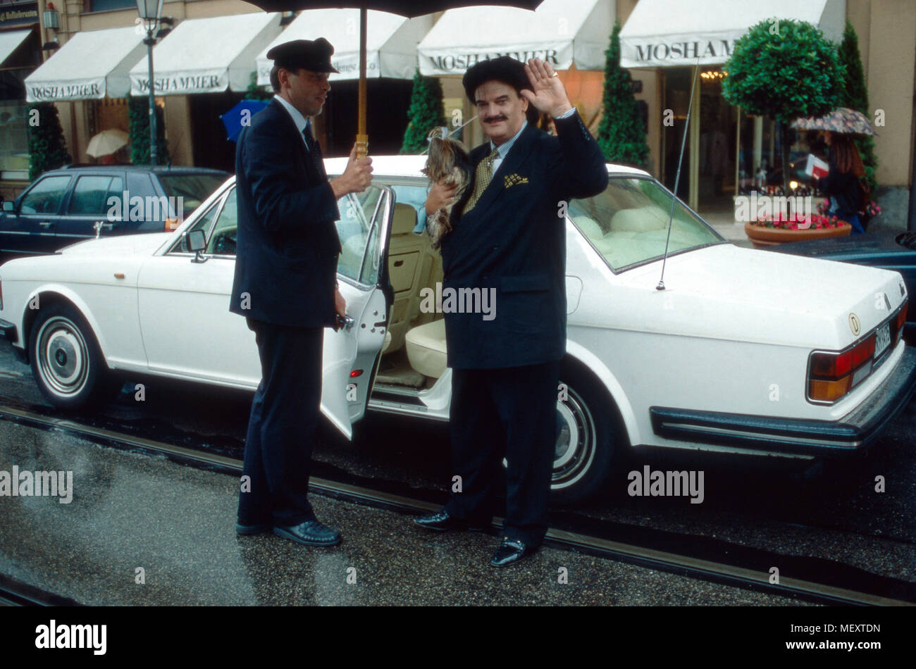 Modedesigner Rudolph Moshammer mit Yorkshire Terrier Daisy und Fahrer Andreas vor seinem Rolls Royce in München, Deutschland 1996. Fashion designer Rudolph Moshammer con Yorkshire terrier Daisy e chauffeur Andreas davanti al suo Rolls Royce a Monaco di Baviera, Germania 1996. Foto Stock