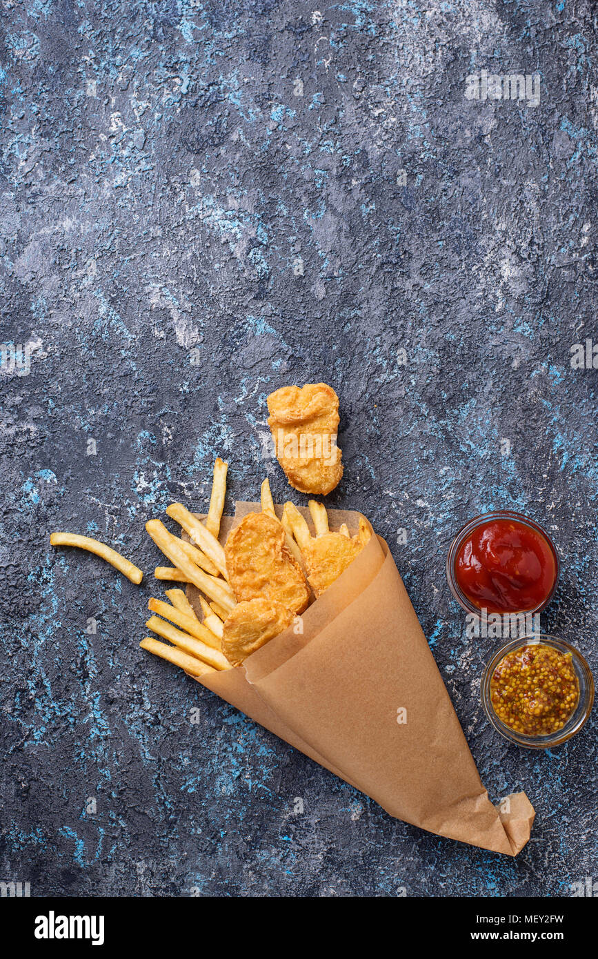 Pesce e patatine fritte con salsa di pomodoro e senape Foto Stock