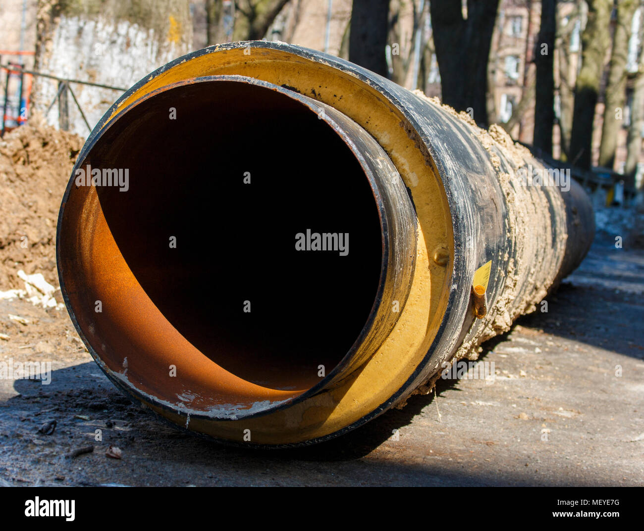 Di grande diametro tubo di sporco si posa su asfalto dopo trascinando fuori dal terreno Foto Stock