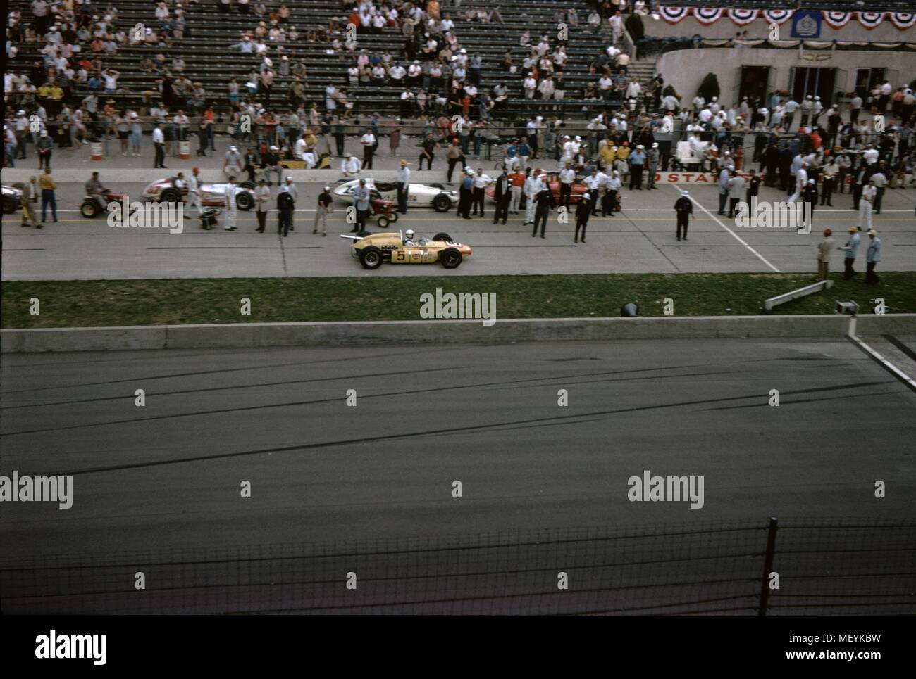 Auto da corsa e gli spettatori sono visibili a Indianapolis 500 gara automobilistica di Indianapolis Motor Speedway di Indianapolis, Indiana, 1965. () Foto Stock