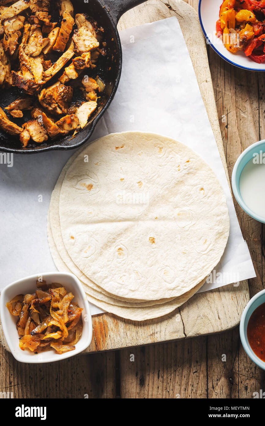Le fajitas di pollo. Marinata di pezzi di pollo con peperoni rossi e gialli e le cipolle con salsa di pomodoro e panna acida e tortilla avvolge Foto stock - Alamy Le fajitas di pollo. Marinata di pezzi di pollo con peperoni rossi e gialli e le cipolle con salsa di pomodoro e panna acida e tortilla avvolge Foto stock - Alamy