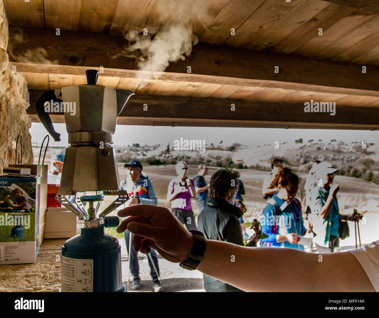 Picnic italiano alla maratona escursionistica. L'espresso si stema sopra la stufa a gas da campeggio Foto Stock