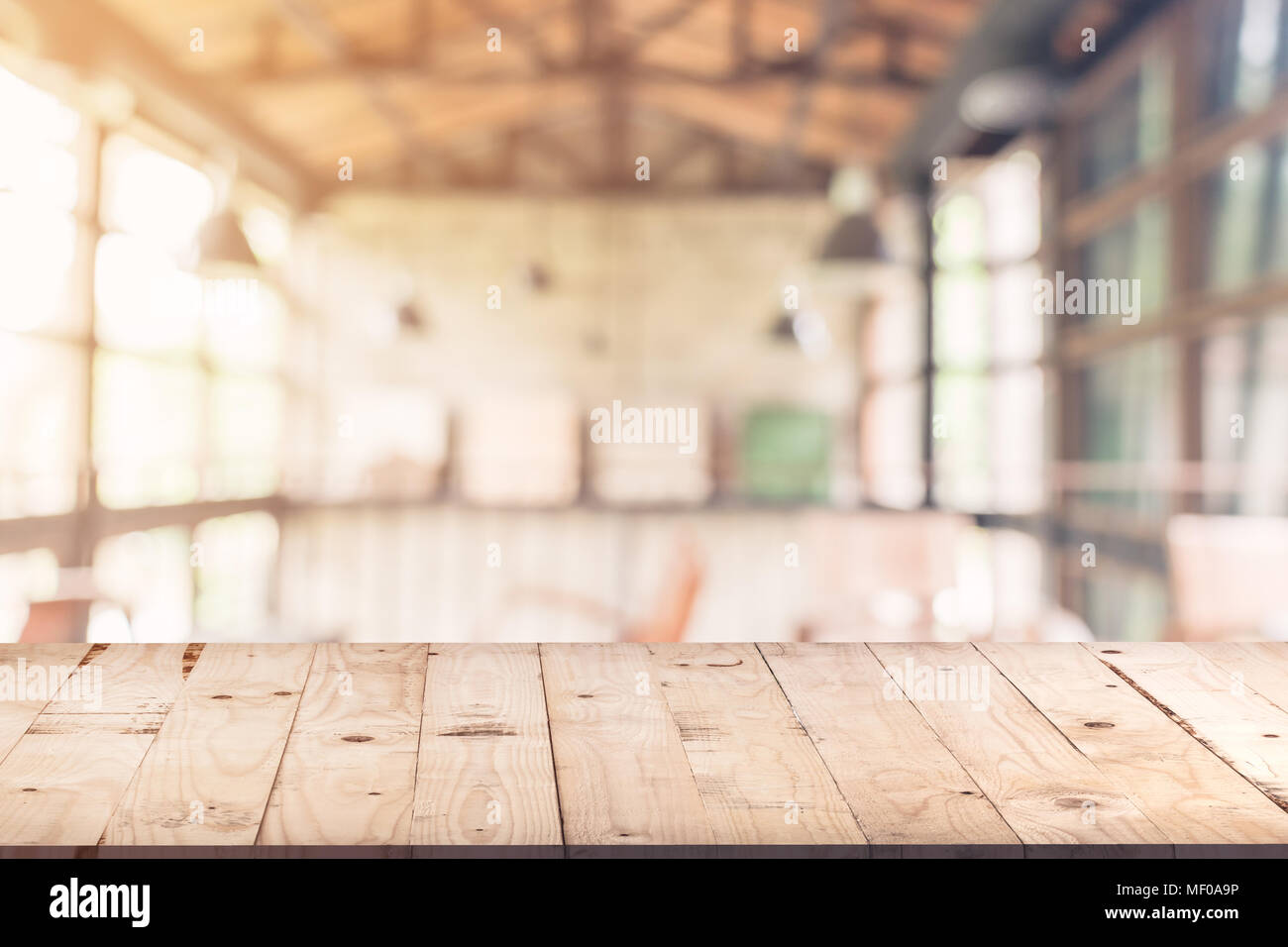 Svuotare tavolo in legno e sfondo sfocato : il cliente presso la caffetteria la sfocatura dello sfondo con bokeh, Vintage tonica. Foto Stock