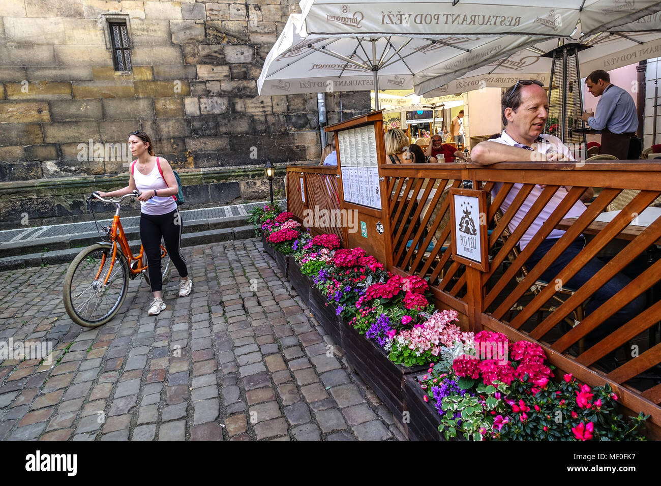 Donna push bike e ristorante vicino al Ponte Carlo, Mala strana, Praga, Repubblica Ceca Foto Stock