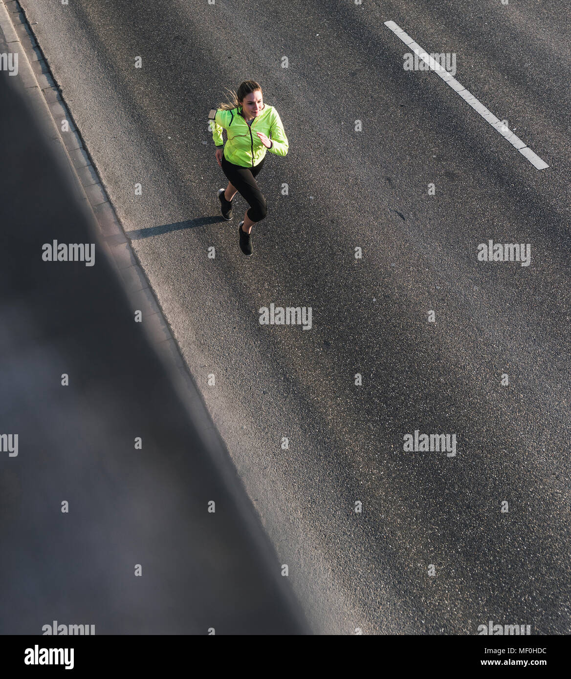 Giovane donna in esecuzione su una strada Foto Stock
