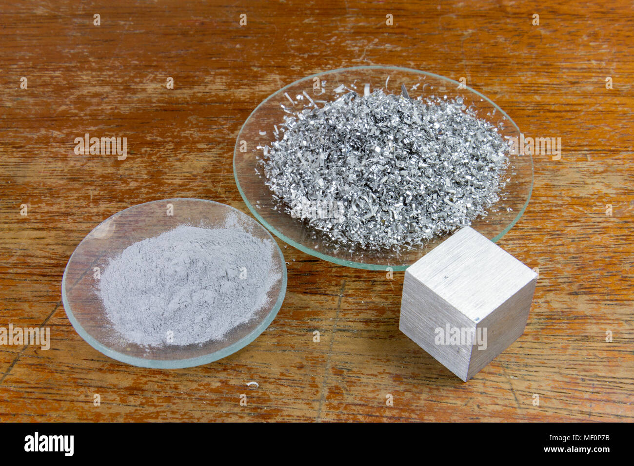 Tre forme di alluminio, come polvere, trucioli e blocco di metallo solido, come utilizzato in un Regno Unito di scuola secondaria. Foto Stock