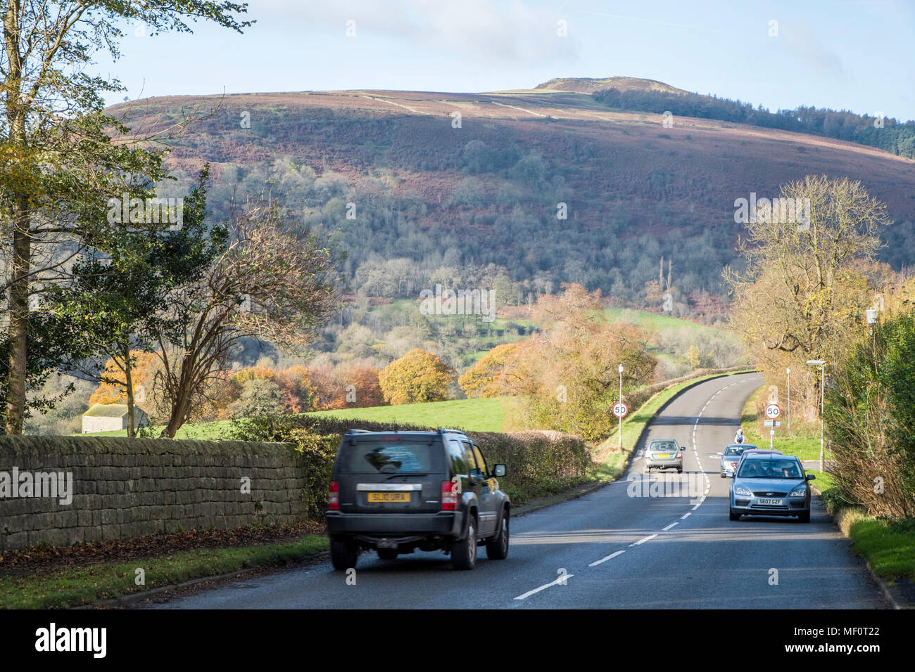 Auto su una strada di campagna nel Peak District con Win Hill nella distanza. Bamford, Derbyshire, Inghilterra, Regno Unito. Foto Stock