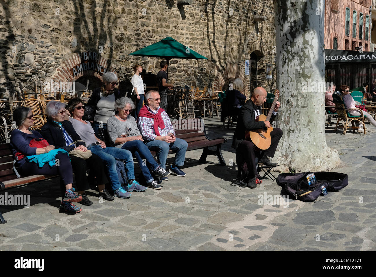 I turisti a guardare un suonatore ambulante di Collioure, Francia. Foto Stock