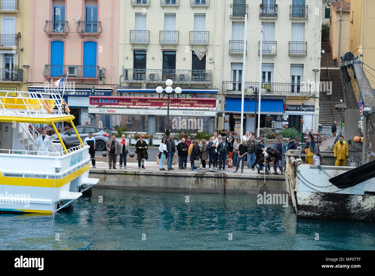 I turisti sulla banchina di un porto di pesca in Francia Foto Stock