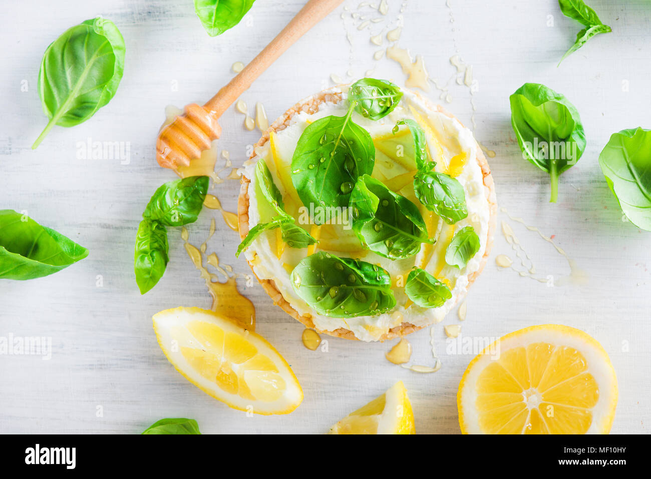 Snack sani con pane croccante, scorza di limone e il miele e il basilico. Antipasto facile ricetta. Foto Stock