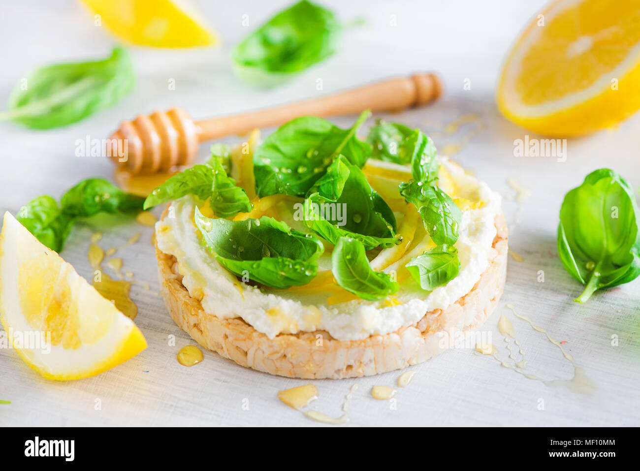 Snack sani con pane croccante, scorza di limone e il miele e il basilico. Antipasto facile ricetta. Foto Stock