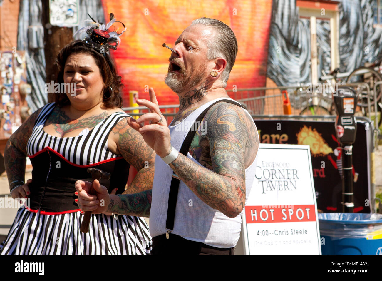 Un freak mostra artista smorfie dopo aver guidato un chiodo nel suo naso, mentre si esegue presso il fuoco nel quarto Festival il 2 maggio 2015 ad Atlanta, GA. Foto Stock